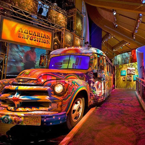 Image of the colorful magic bus at the woodstock museum, surrounded by other museum exhibits