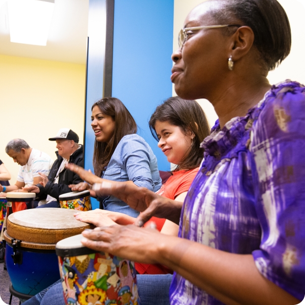 In a music class, a row of 5 people play drums with their hands