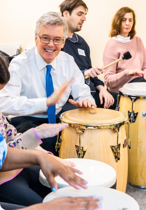 DMF Artistic Director Gerry shows a group of participants how to play drums with their hands