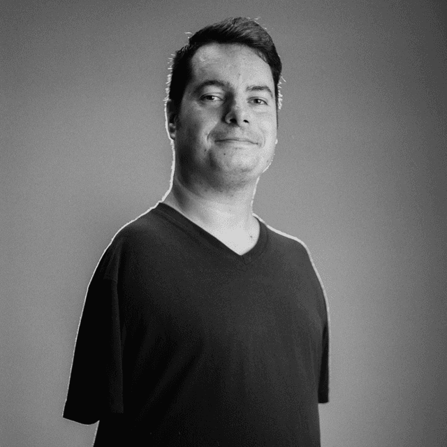 Black and white photo of George Dennehy. He is a Caucasian man in his early 30s, with short brown hair. He is wearing a T shirt, and has no arms.