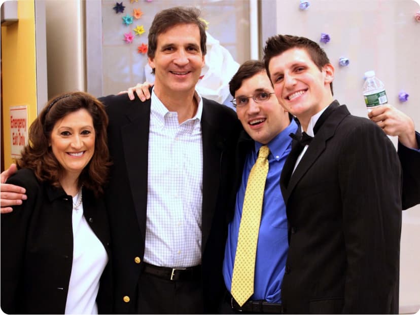 Nancy, Ken, Daniel, and Michael Trush stand smiling with their arms around each other