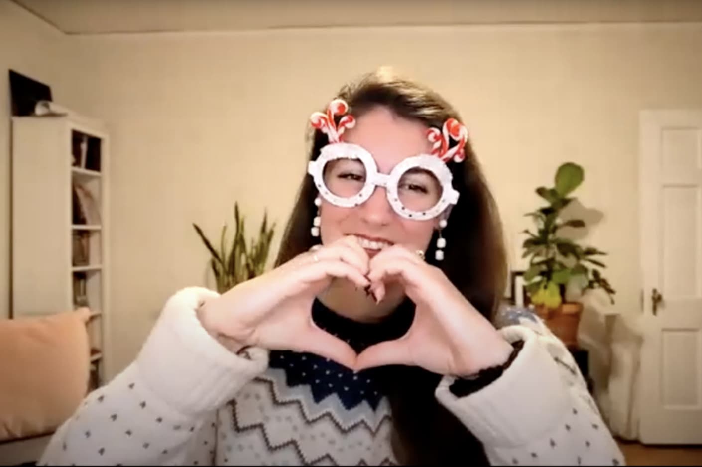 In a screenshot from an online event, DMF Instructor Jennifer wears silly fake glasses and makes a heart with her hands