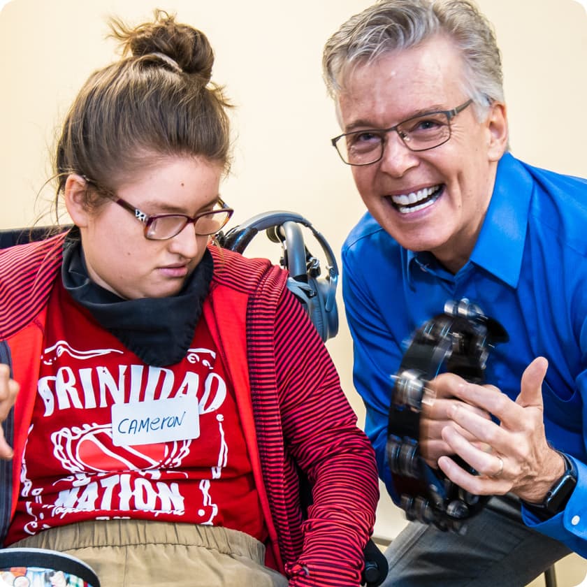 DMF Artistic Director Gerry plays a tambourine with a DMF participant