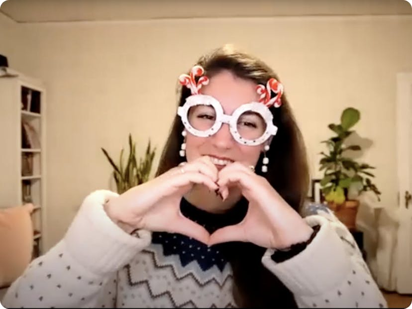 In a screenshot from an online event, DMF Instructor Jennifer wears silly fake glasses and makes a heart with her hands